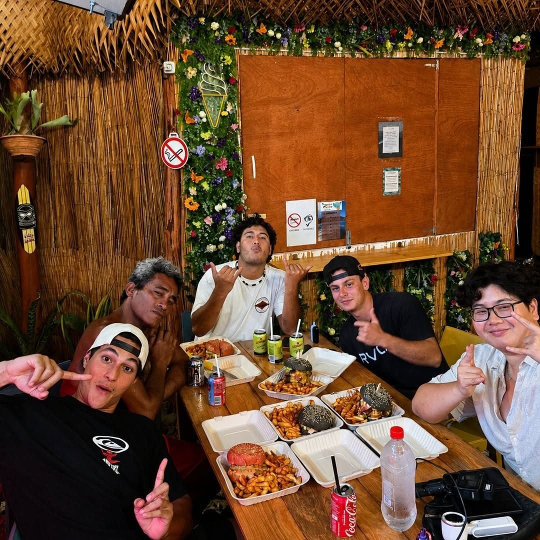 Une bande d'amis attablés sous la paillote de la roulotte, burgers et frites